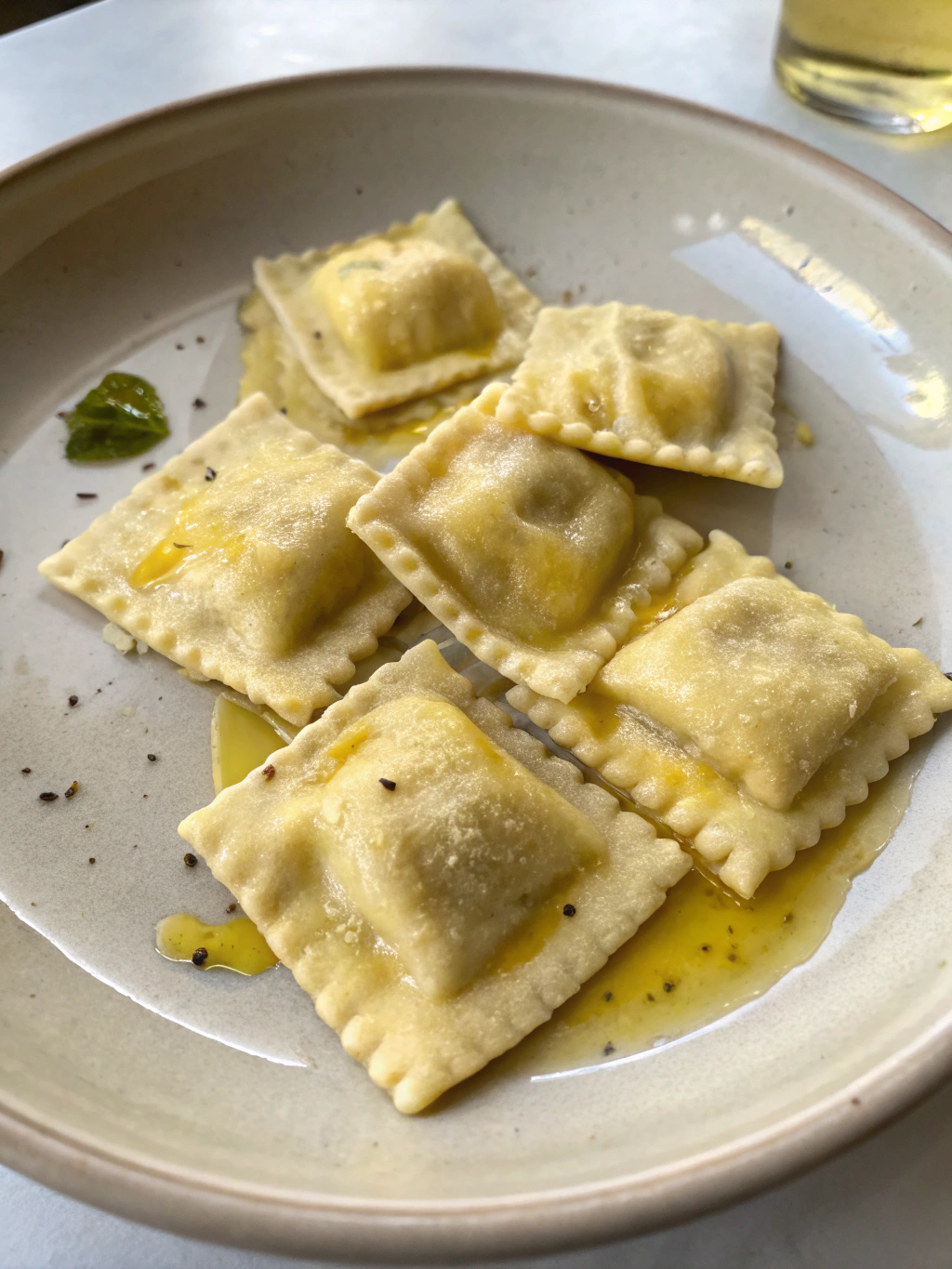 Préparez de savoureuses ravioles maison farcies à la ricotta, servies chaudes avec un filet d’huile d’olive et du parmesan râpé