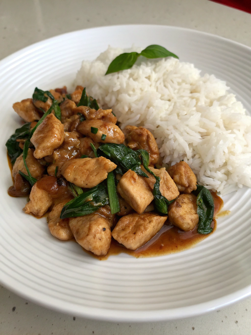 Présentation élégante du poulet thai basilic dans un bol avec riz et garniture