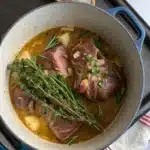 Jarret agneau rôti mijoté au vin blanc avec carottes fondantes et aromates, servi bien chaud pour un plat généreux et réconfortant.