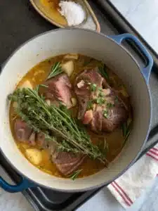 Jarret agneau rôti mijoté au vin blanc avec carottes fondantes et aromates, servi bien chaud pour un plat généreux et réconfortant.