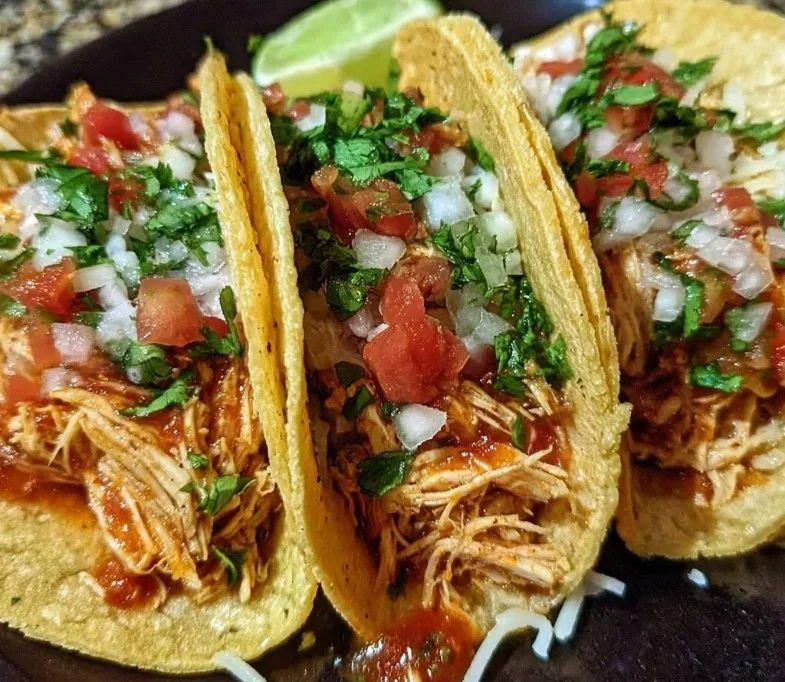 shredded chicken tacos in crockpot with forks ready to serve