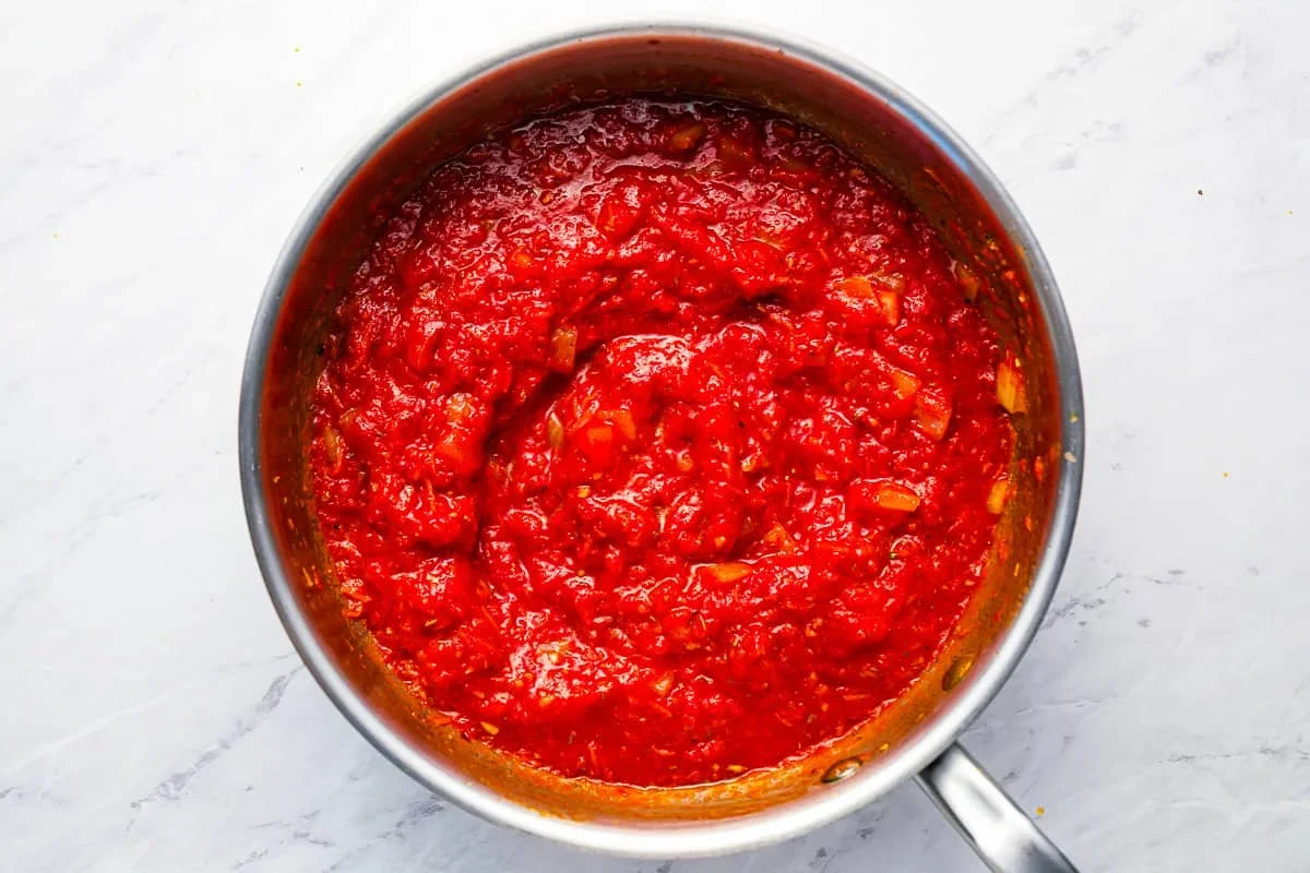 thick spaghetti sauce simmering on stove with spoon