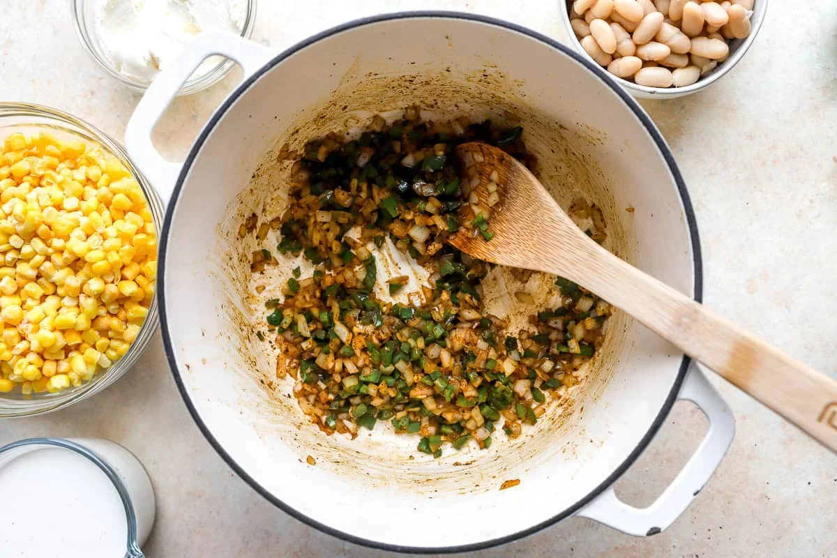 chicken simmering in broth for street corn white chili
